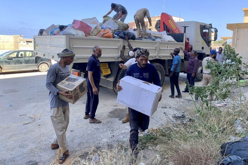 Personas entregan donativos el sábado 16 de septiembre de 2023, en la ciudad de Derma, la cual quedó destruida por inundaciones, en Libia. (AP Foto/Yousef Murad, Archivo)
