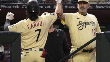 Corbin Carroll, de los Diamondbacks de Arizona, intercambia una palmada del manager Torey Lovullo (17) luego de conectar un jonrón en el juego del iernes 5 de mayo de 2023, ante los Nacionales de Washington (AP Foto/Rick Scuteri)