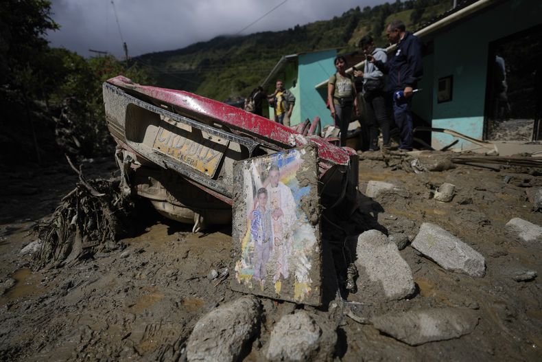 Restos de un automóvil y una foto embarrada yacían en la calle después de que una avalancha mortal cubriera casas durante la noche en El Naranjal, Colombia, el martes 18 de julio de 2023. (Foto AP/Fernando Vergara)