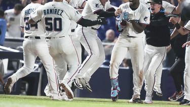 Jesús Sánchez, con banda en la cabeza, de los Marlins de Miami, celebra con sus compañeros de equipo después de batear un triple para dejar tendidos a los Cachorros de Chicago en juego de béisbol de Grandes Ligas, el lunes 19 de mayo de 2025, en Miami. (AP Foto/Lynne Sladky)