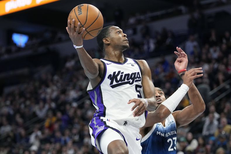 DeAaron Fox, base de los Kings de Sacramento, salta para encestar ante Troy Brown Jr., de los Timberwolves de Minnesota, el viernes 24 de noviembre de 2023 (AP Foto/Abbie Parr)