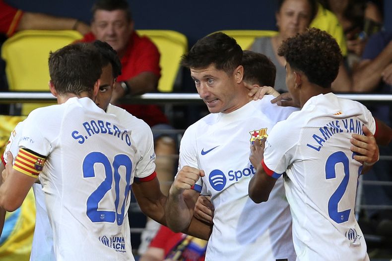 Robert Lewandowski (centro) festeja tras anotar el cuarto gol del Barcelona en la victoria 4-3 ante el Villarreal en la Liga española, el domingo 27 de agosto de 2023. (AP Foto/Alberto Saiz)