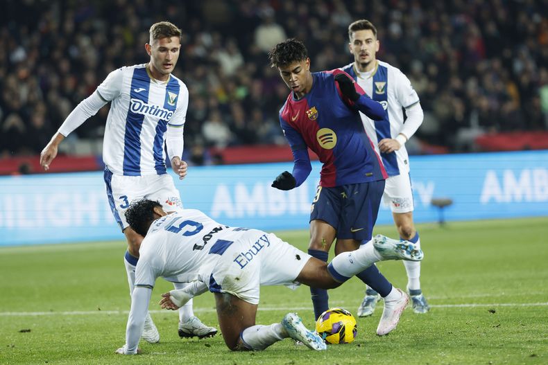 Lamine Yamal del Barcelona y Renato Tapia del Leganes pelean por el balón en el encuentro de la liga española del domingo 15 de diciembre del 2024. (AP Foto/Joan Monfort)