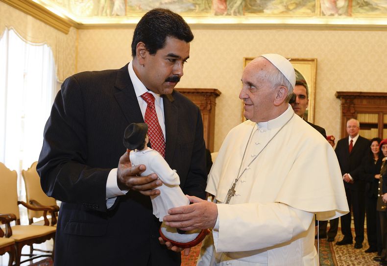 ARCHIVO - El presidente venezolano Nicolás Maduro, a la izquierda, entrega al papa Francisco una estatuilla del doctor José Gregorio Hernández, una figura popular entre los venezolanos, en el Vaticano el 17 de junio de 2012. El papa Francisco dijo que Venezuela vive una situación crítica en su homilía tradicional del domingo 4 de agosto de 2024 en el Vaticano. (Andreas Solaro, foto compartida, vía AP, Archivo)