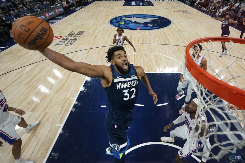Karl-Anthony Towns, de los Timberwolves de Minnesota, salta para realizar una clavada en el duelo ante los 76ers de Filadelfia, el miércoles 22 de noviembre de 2023, en Minneapolis. (AP Foto/Abbie Parr)