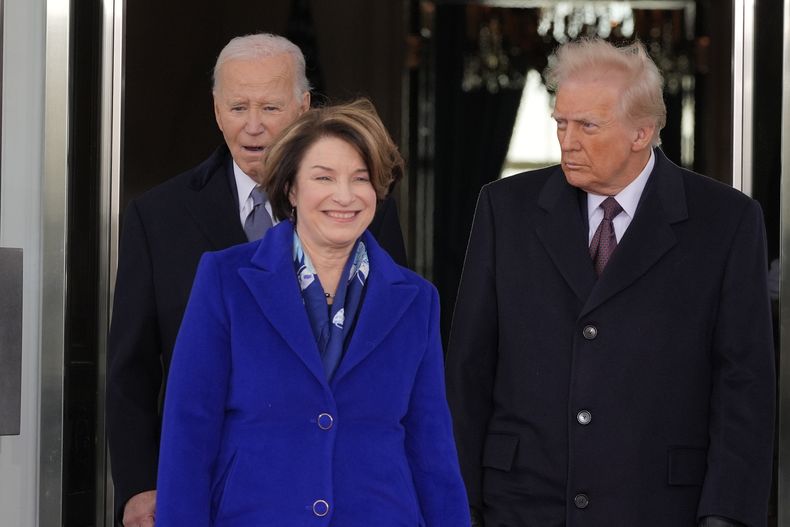 El presidente Joe Biden y el presidente electo Donald Trump, escoltados por la senadora Amy Klobuchar, demócrata por Minnesota, caminan hacia la limusina presidencial cuando salen de la Casa Blanca, el lunes 20 de enero de 2025, en Washington, de camino al Capitolio. (AP Foto/Alex Brandon)