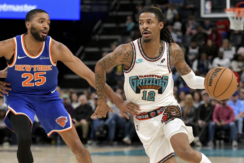 El escolta de los Grizzlies de Memphis, Ja Morant (12), maneja el balón contra el alero de los Knicks de Nueva York, Mikal Bridges (25), en la segunda mitad de un partido de baloncesto de la NBA, el viernes 28 de febrero de 2025, en Memphis, Tennessee.