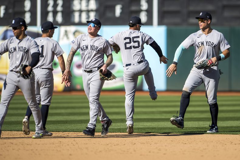 El jardinero de los Yankees de Nueva York, Aaron Judge, a la derecha, celebra una victoria con el segunda base Gleyber Torres (25) después de un juego contra los Atléticos de Oakland en Oakland, California, el domingo 22 de septiembre de 2024. (AP Foto/Nic Coury)