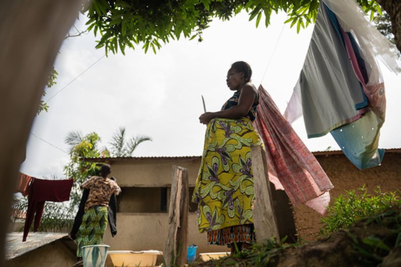 Elodie, a la derecha, madre de un hijo y embarazada de ocho meses, se ve de pie ante su casa en Bunia, en el nordeste de República Democrática del Congo, el martes 16 de junio de 2026. (AP foto/Moses Sawasawa)