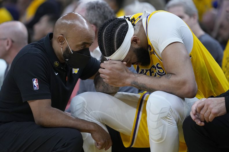 Anthony Davis, alero de los Lakers de Los Ángeles, se sienta en el banquillo tras lastimarse en un partido de playoffs ante los Warriors de Golden State, el miércoles 10 de mayo de 2023 (AP Foto/Godofredo A. Vásquez)