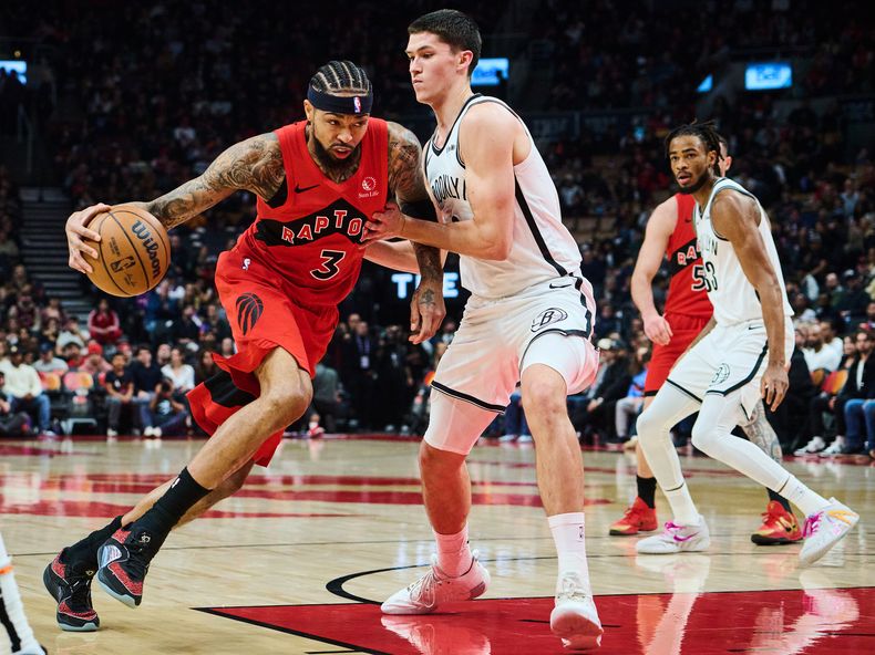 Brandon Ingram (3), de los Raptors de Toronto, conduce a través de Egor Dëmin (8), de los Nets de Brooklyn, durante el juego de baloncesto de la NBA en la primera mitad en Toronto, el domingo 23 de noviembre de 2025. (Sammy Kogan/The Canadian Press vía AP)
