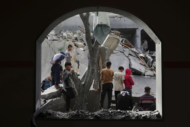 Palestinos miran un lugar alcanzado por un ataque israelí en Deir al Balah, Franja de Gaza, el lunes 7 de abril de 2025. (AP Foto/Abdel Kareem Hana)