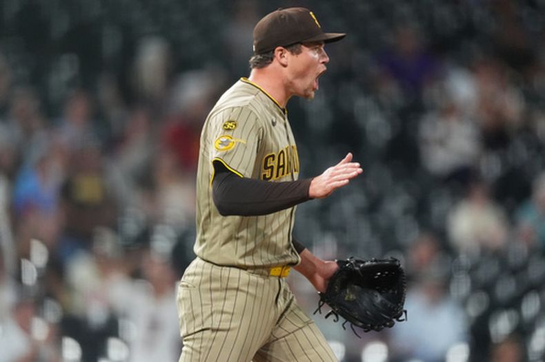 El relevista de los Padres de San Diego, Mason Miller, reacciona después de que el tercera base Manny Machado fildeó un rodado y puso fuera al pelotero de los Rockies de Colorado, Adael Amador, para poner fin a la novena entrada de un partido de béisbol el lunes 14 de septiembre de 2026, en Denver. (Foto AP/David Zalubowski)