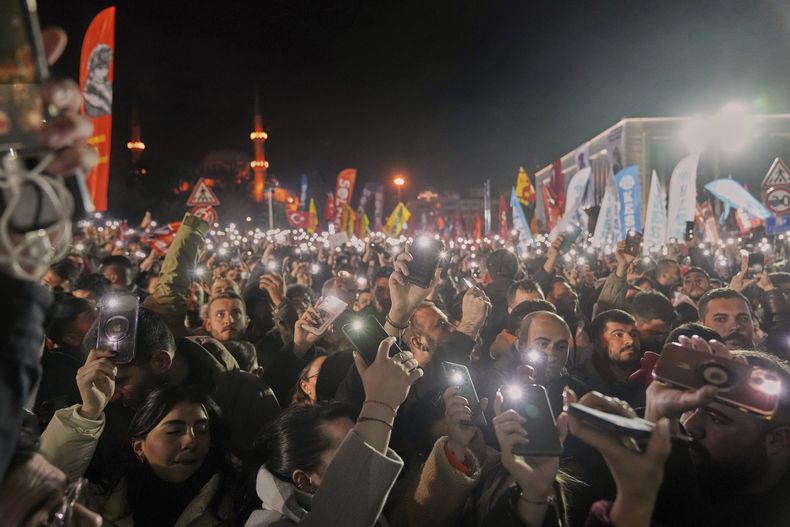 Gente alza sus celulares tras reunirse ante el ayuntamiento para protestar por la detención del alcalde de Estambul, Ekrem Imamoglu, en Estambul Turquía, el miércoles 19 de marzo de 2025. (AP Foto/Francisco Seco)