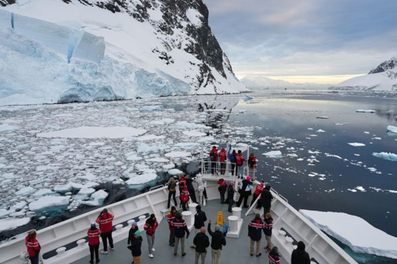 ARCHIVO - Pasajeros miran mientras un barco navega por el canal de Lemaire en Antártida, el lunes 24 de noviembre de 2025. (AP Foto/Mark Baker, Archivo)