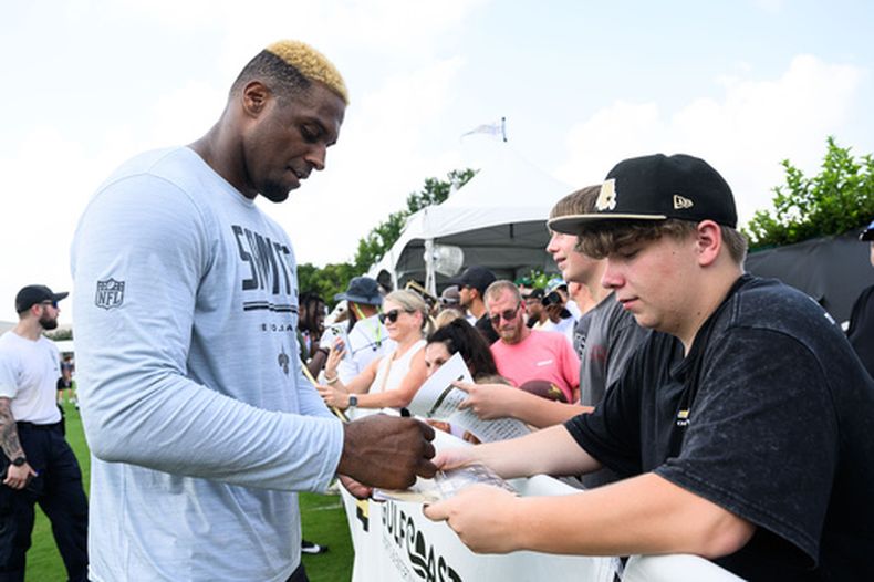El ala defensiva de los Saints de Nueva Orleans, Cameron Jordan (94), interactúa con los aficionados después de la práctica en el campamento de entrenamiento de fútbol americano del equipo en Metairie, Luisiana, el jueves 30 de julio de 2026. (Foto AP/Ella Hall)