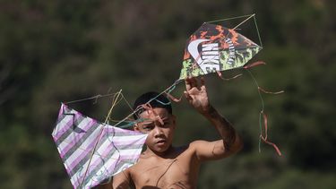 Un joven sostiene cometas durante un festival en la favela de Turano, en Río de Janeiro, el domingo 7 de julio de 2024. (AP Foto/Bruna Prado)