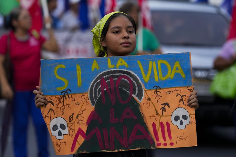 Una manifestante sostiene una pancarta durante una protesta en las proximidades de la Asamblea Nacional de Panamá en contra del contrato firmado por el gobierno y una minera de Canadá para explorar cobre en una zona boscosa del norte del país, en ciudad de Panamá, el jueves 19 de octubre del 2023. (AP Foto AP/Arnulfo Franco)