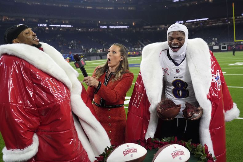 El corredor de los Ravens de Baltimore, Derrick Henry, a la izquierda, y el quarterback Lamar Jackson (8) son entrevistados por el reportero de Netflix Jamie Erdahl después de un partido contra los Texans de Houston, el miércoles 25 de diciembre de 2024, en Houston. (AP Foto/David J. Phillip)