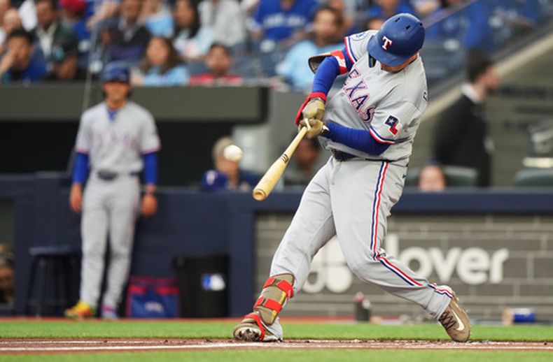 El bateador designado de los Rangers de Texas, Joc Pederson (3), conecta un jonrón solitario contra los Azulejos de Toronto durante la primera entrada de un partido de béisbol en Toronto, el jueves 25 de junio de 2026. (Nathan Denette/The Canadian Press vía AP)