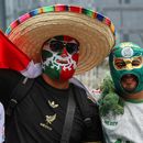 Aficionados mexicanos con máscaras llegan a una fiesta cerca del Ángel de la Independencia en la capital de su país, el domingo 5 de julio de 2026 (AP Foto/Ginnette Riquelme)