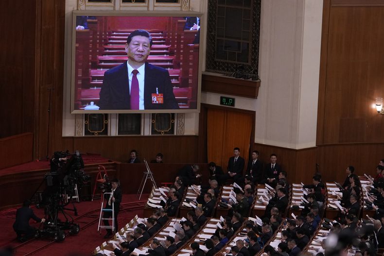 El presidente de China Xi Jinping, en la pantalla, escucha la declaración inicial del premier chino Li Qiang, durante la sesión inaugural de la Asamblea Popular Nacional en el Gran Salón del Pueblo, el martes 5 de marzo de 2024, en Beijing. (AP Foto/Andy Wong)
