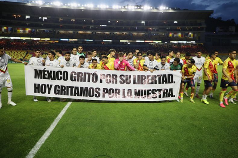 Jugadores de Atlético Morelia y Leones Negros sostienen una manta en la que se lee: México gritó por su libertad. Hoy gritamos por la nuestra, previo al partido de fútbol de la segunda división, en Morelia, Michoacán, el sábado 19 de septiembre de 2026. (AP Foto/Armando Solis)