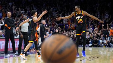 Devin Booker (izquierda) festeja un enceste con su compañero de los Suns de Phoenix, Kevin Durant, en el tercer partido de las semifinales de la Conferencia Oeste frente a los Nuggets de Denver, el viernes 5 de mayo de 2023 (AP Foto/Matt York)