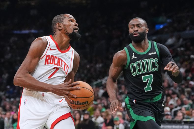 Kevin Durant, de los Rockets de Houston, a la izquierda, avanza hacia la canasta contra Jaylen Brown, delantero de los Celtics de Boston, durante la primera mitad de un juego de baloncesto de la NBA, el sábado 1 de noviembre de 2025, en Boston. (AP Photo/Charles Krupa)