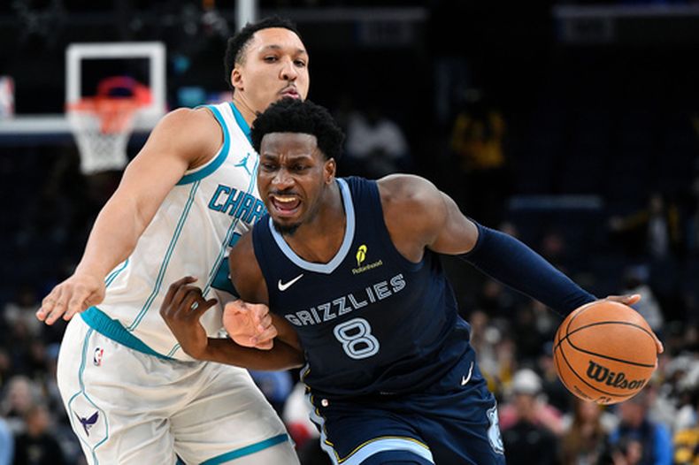Jaren Jackson Jr. (8), de los Grizzlies de Memphis, maneja el balón ante Grant Williams (2), de los Hornets de Charlotte, en la segunda mitad de un juego de baloncesto de la NBA en Memphis, Tennessee, el miércoles 28 de enero de 2026. (AP Photo/Brandon Dill)