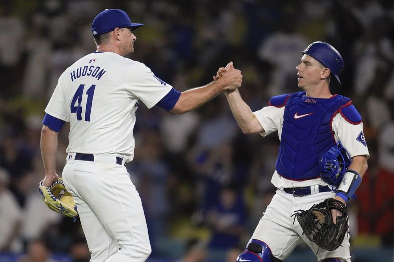 El lanzador relevista de los Dodgers de Los Ángeles, Daniel Hudson (41), estrecha la mano del receptor Will Smith después de una victoria sobre los Gigantes de San Francisco el lunes 22 de julio de 2024, en Los Ángeles. (AP Foto/Marcio José Sánchez)
