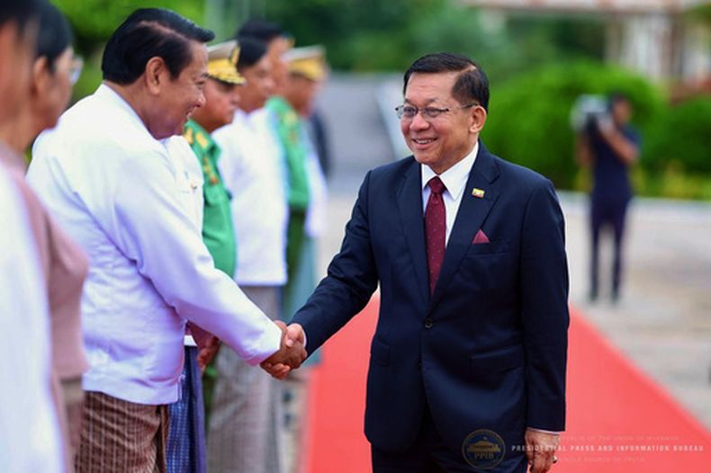 En esta imagen publicada por la oficina del presidente de Myanmar, el presidente de Myanmar, Min Aung Hlaing, a la derecha, estrecha la mano del presidente de la Cámara Baja, Khin Yi, a su salida hacia Rusia en el aeropuerto internacional de Naipyidó, Myanmar, el lunes 17 de agosto de 2026. (Oficina del presidente de Myanmar via AP)