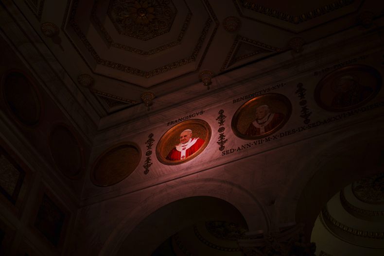 ARCHIVO - Una luz ilumina un retrato en mosaico policromado del Papa Francisco colocado en el friso de la Basílica de San Pablo Extramuros en Roma, el miércoles 26 de febrero de 2025. (Foto AP/Bernat Armangue, archivo)