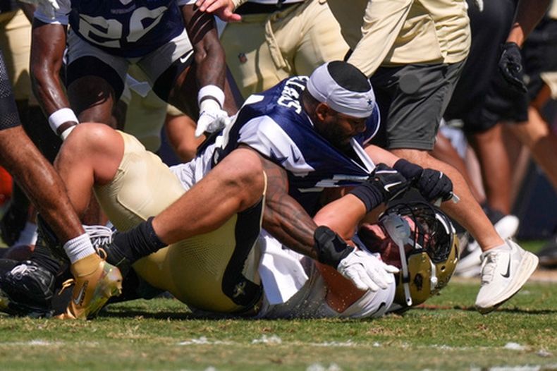 El apoyador externo de los Cowboys de Dallas, Sam Williams (arriba), forcejea con el ala cerrada de los Saints de Nueva Orleans, Moliki Matavao, durante una práctica conjunta de fútbol americano de la NFL, el martes 18 de agosto de 2026, en Oxnard, California. (Foto AP/Mark J. Terrill)