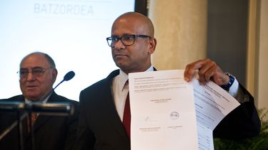 americateve | Ram Manikkalingam, miembro de la comisi[on que supervisa el cese de fuego del grupo separatista vasco ETA, anunciado en 2011, muestra un documento de ETA despu&eacute;s que el grupo anunci&oacute; un primer gesto de desarme, decomisioando un peque&ntilde;
