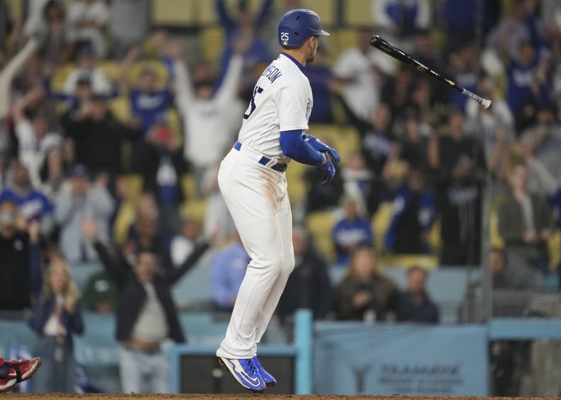 Trayce Thompson (25), de los Dodgers de Los Ángeles, arroja su bate tras recibir base por bolas en la 12ma entrada del partido contra los Mellizos de Minnesota en Los Ángeles, el lunes 15 de mayo de 2023. (AP Foto/Ashley Landis)