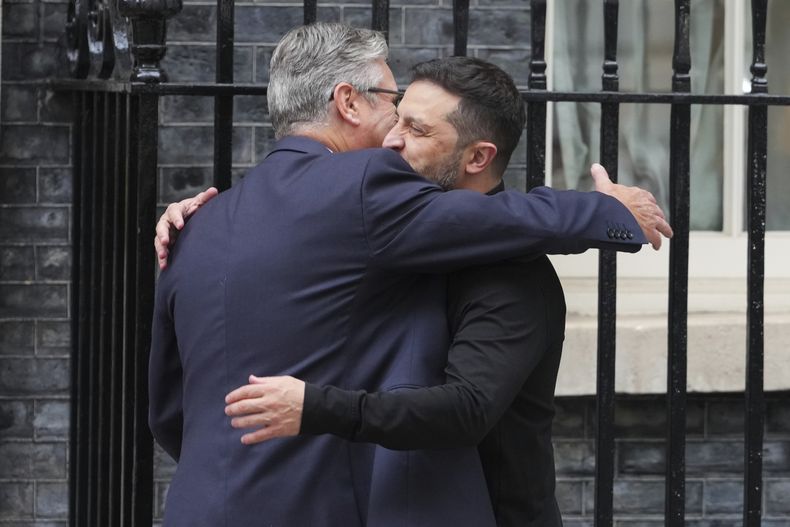 El primer ministro británico, Keir Starmer (izquierda), abraza al presidente ucraniano, Volodymyr Zelenskyy, a su llegada a la calle Downing, donde está su residencia oficial, en el centro de Londres, el 14 de agosto de 2025. (AP Foto/Kirsty Wigglesworth)
