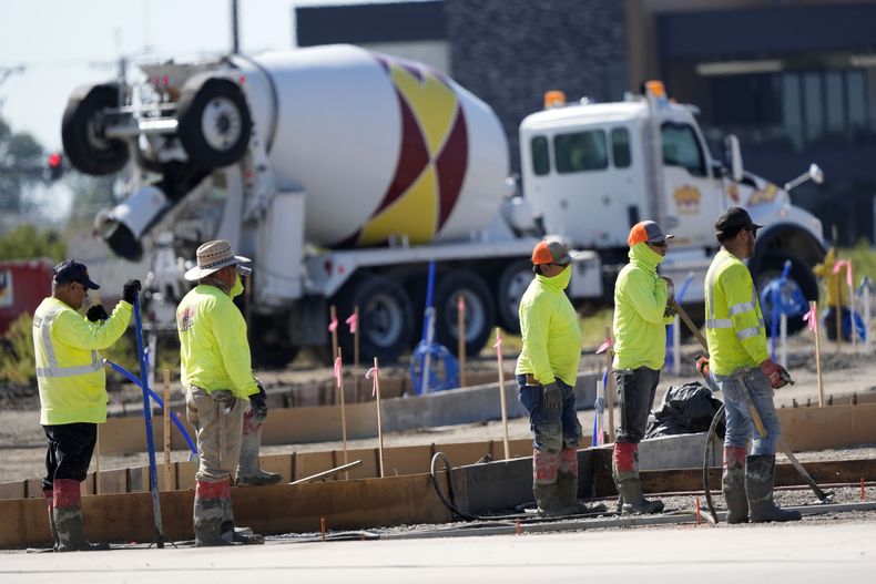 ARCHIVO – Miembros de un equipo de construcción esperan para verter concreto en un estacionamiento, el 4 de septiembre de 2024, en Waukee, Iowa. (AP Foto/Charlie Neibergall, Archivo)
