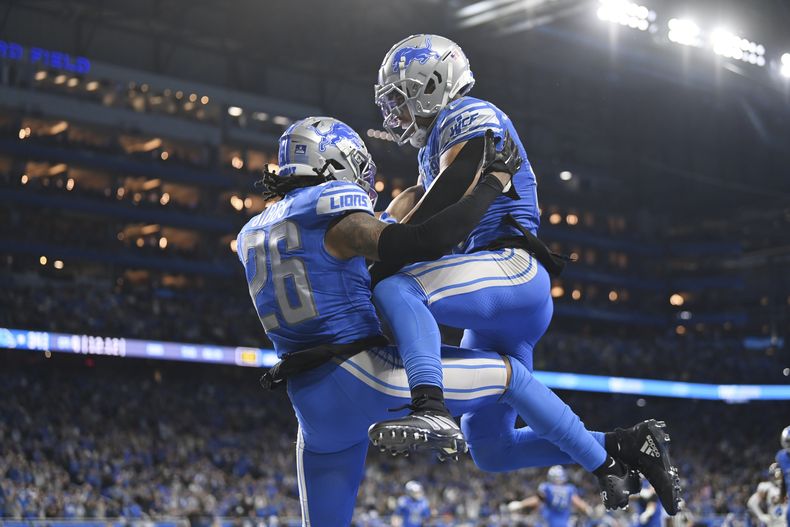 Jahmyr Gibbs (26), corredor de los Lions de Detroit, festeja tras un acarreo de anotación de 12 yardas, en el encuentro del sábado 16 de diciembre de 2023, ante los Broncos de Denver (AP Foto/David Dermer)