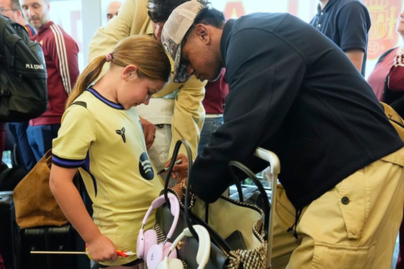 Lamine Yamal (derecha) firma un autógrafo a Griffin Wamp tras el arribo de la selección de España para el Mundial, el viernes 5 de junio de 2026, en Chattanooga, Tennessee. (AP Foto/George Walker IV)