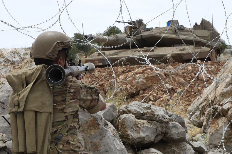 Un soldado libanés apunta su lanzagranadas hacia un tanque Merkava israelí en las colinas de Kfar Chouba en la frontera, sur del Líbano, viernes 9 de junio de 2023. Soldados israelíes lanzaron gases lacrimógenos para dispersar a decenas de manifestantes que arrojaban piedras a las tropas en la frontera con Líbano el viernes, y algunos manifestantes y soldados sufrieron problemas respiratorios. (AP Foto/Mohammad Zaatari)