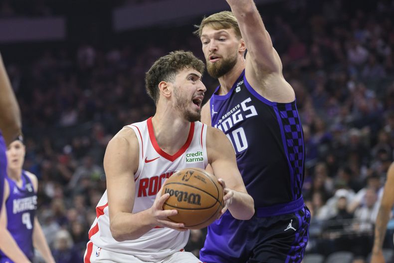 El centro de los Rockets de Houston Alperen Sengun (izquierda) es marcado por el ala-pívot de los Kings de Sacramento Domantas Sabonis durante la primera mitad del juego de baloncesto de la NBA, en Sacramento, California, el domingo 10 de marzo de 2024. (AP Foto/Randall Benton)