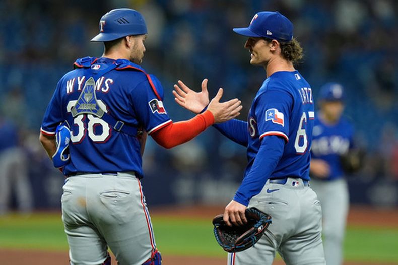 Jacob Latz, pitcher de los Rangers de Texas, celebra con el receptor Austin Wynns, tras cerrar el jueggo ante los Rays de Tampa Bay, el martes 28 de julio de 2026 (AP Foto/Chris OMeara)