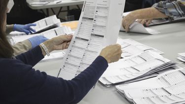 ARCHIVO - Un trabajador electoral examina una papeleta en la oficina electoral del condado de Clackamas el 19 de mayo de 2022, en Oregon City, Oregón. (AP Foto/Gillian Flaccus, Archivo)