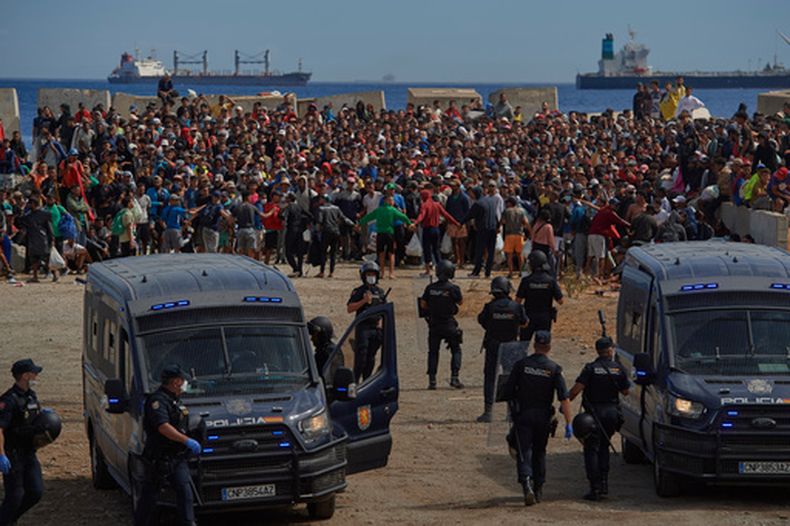 ARCHIVO - Migrantes que cruzaron de Marruecos a España regresan a una playa tras haber sido expulsados de la zona el día anterior, cuando la policía española los escolta en el enclave español de Ceuta, el 21 de agosto de 2026. (Foto AP/Antonio Sempere, archivo)