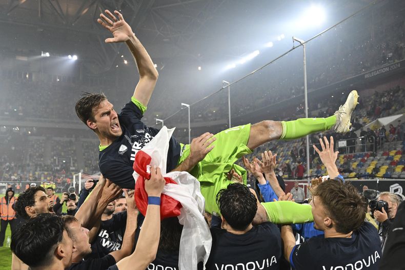 Los jugadores de Bochum celebran tras asegurar la permanencia en la primera división con una victoria ante Fortuna Duesseldorf, el lunes 27 de mayo de 2024. (Marius Becker/dpa vía AP)