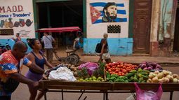 Vendedores ambulantes empujan su carrito de verduras frente a un mural de Fidel Castro en La Habana, Cuba, el miércoles 12 de agosto de 2026. (Foto AP/Ramón Espinosa)