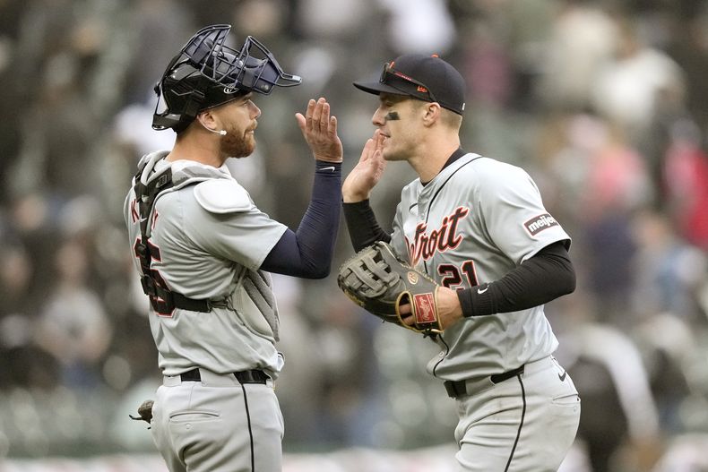 El cátcher de los Tigres de Detroit Carson Kelly y Mark Canha celebran la victoria 7-6 ante los Medias Blancas de Chicago en la décima entrada el sábado 30 de marzo del 2024. (AP Foto/Charles Rex Arbogast)