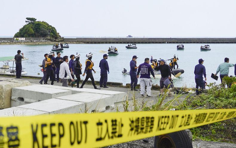 Miembros de la Guardia Costera se preparan para buscar barcos naufragados en un puerto en Henoko, ciudad de Nago, en la prefectura de Okinawa, el lunes 16 de marzo de 2026. (Kyodo News via AP)