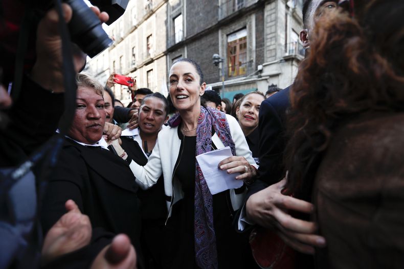 FILE - ARCHIVO – La recién posesionada alcaldesa de Ciudad de México, Claudia Sheinbaum, saluda a la gente a su llegada a un acto en Ciudad de México, el 5 de diciembre de 2018. Su bagaje científico quedó de manifiesto en las decisiones que tomó Sheinbaum como alcaldesa durante la pandemia de COVID-19, cuando la ciudad de unos nueve millones de habitantes optó por un enfoque diferente del que López Obrador propugnaba a nivel nacional. (AP Foto/Eduardo Verdugo, Archivo)